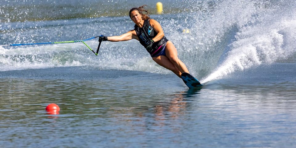 Kristy Kraus rounding a slalom buoy in a wall of spray